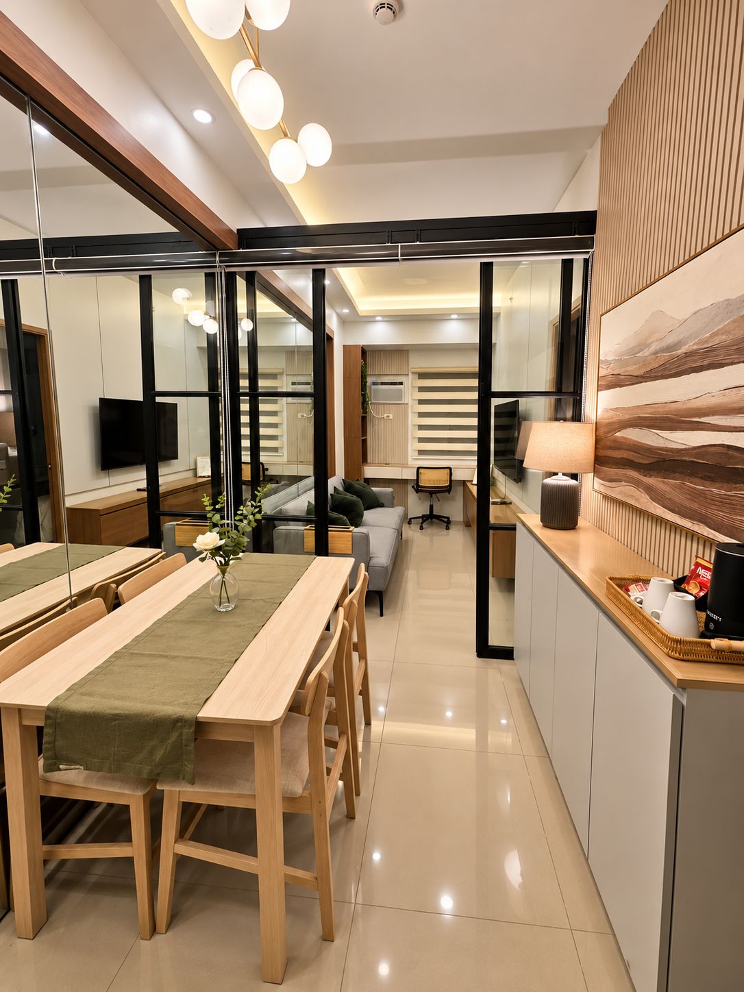 A modern kitchen with a dining area, a sofa, and a TV.