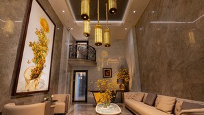 Un lobby moderno con un sofá, sillas, una mesa de centro y una escalera.