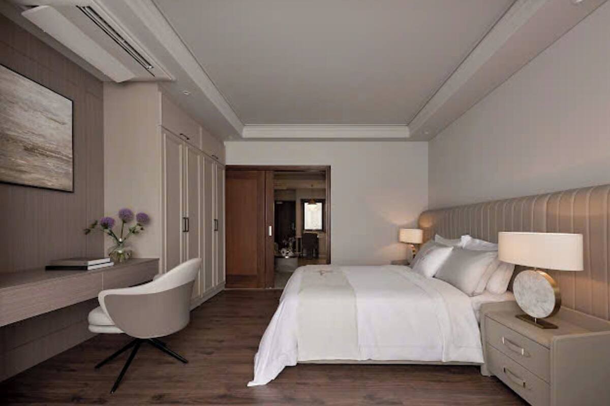 Una habitación de hotel moderna con una cama grande, un escritorio y una silla.