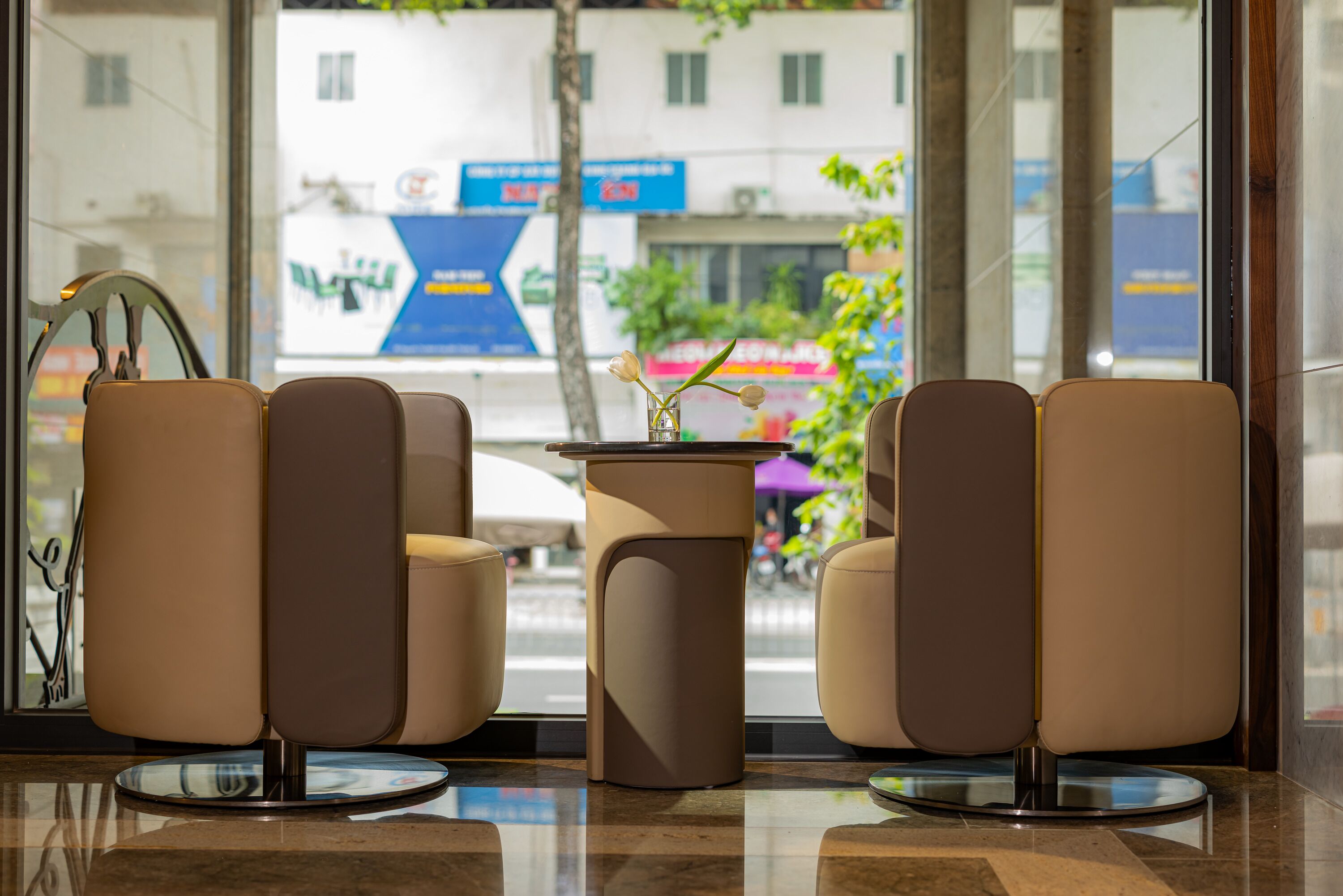 A reception area with a modern design, featuring a seating arrangement with two chairs and a small table.