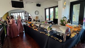 Een buffetopstelling met diverse gerechten en een klok aan de muur.