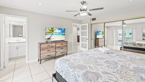 A bedroom with a bed, a TV, a wardrobe, and a ceiling fan. - Beach, Pool; Las Olas Getaway (Fort Lauderdale)