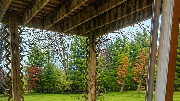 Una vasca idromassaggio su un pontile di legno, con una pergola sopra.