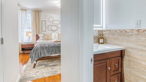 Un dormitorio con cama, mesita de noche y tocador.