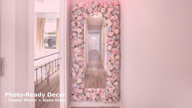 En hall med en spegel prydd med ett blommönster och en neonljusskylt som visar ordet ”kärlek”.