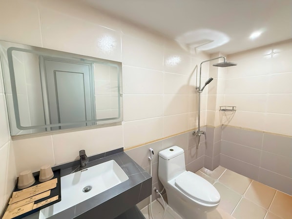 Un baño con lavamanos, inodoro y ducha.