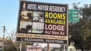 A hotel sign advertising rooms, family rooms, and deluxe rooms with available parking. - Hotel Mayur Residency (Khuldabad)