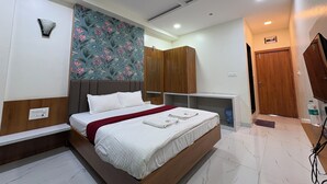 A modern bedroom with a bed, wardrobe, and a television. - Hotel Mayur Residency (Khuldabad)