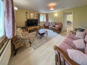 A living room with a sofa, armchairs, a coffee table, and a television. - Hafod Fach - UKC6956 (Moylegrove near Ceibwr Bay)