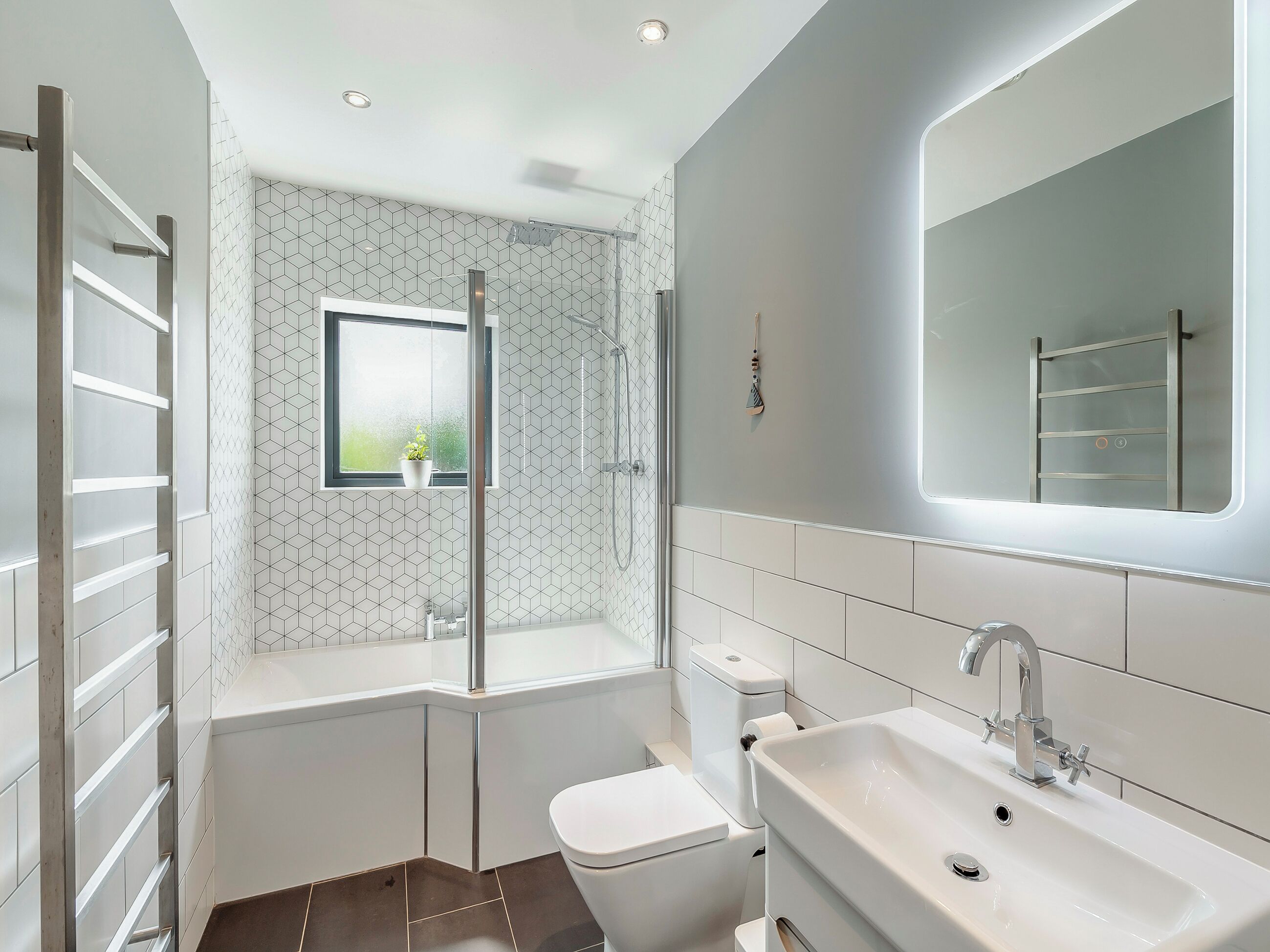 Een moderne badkamer met een inloopdouche, toilet en wastafel.