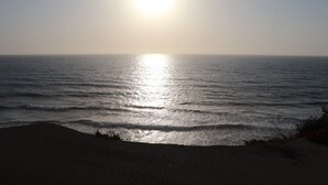 A beach with the sun reflecting off the water.