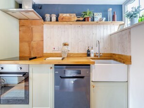 A modern kitchen with wooden countertops, a built-in oven, and a dishwasher.