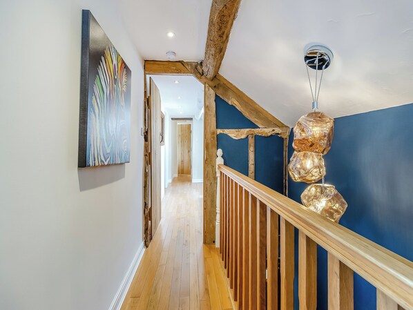 Ein Flur mit Holzboden, blauer Wand und Holzwandhandlauf.