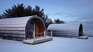 Two snow-covered arched structures with wooden decks and rope barriers, surrounded by trees. - 1 bedroom accommodation in Stranraer (Stranraer)