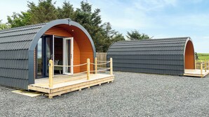 Two modern, arched, pod-style cabins with wooden decks and a gravel ground. - 1 bedroom accommodation in Stranraer (Stranraer)