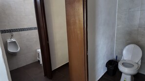 A bathroom with a urinal, toilet, and a trash bin. - Loft Los Pinos (Monterrey)