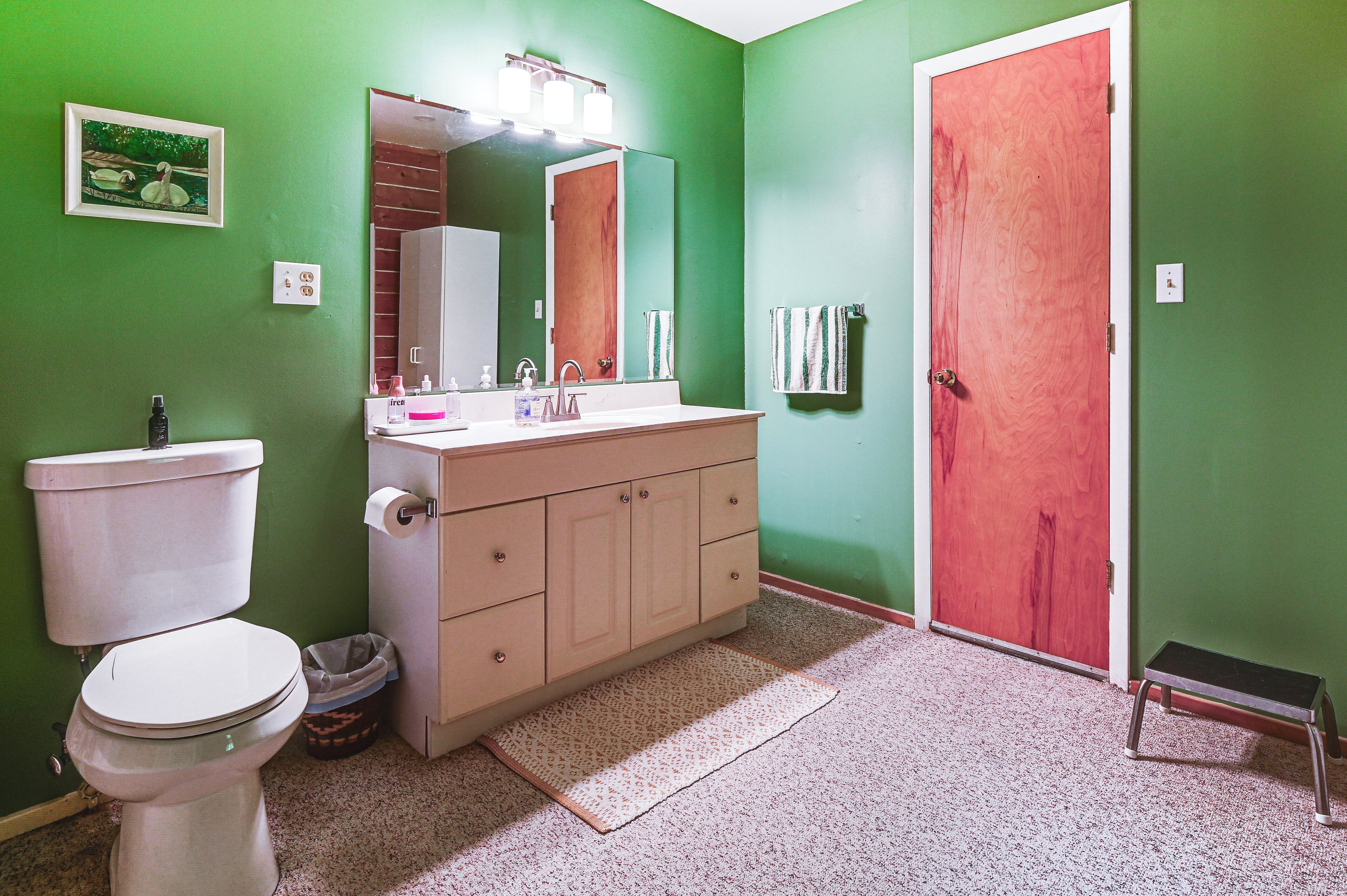 Un baño con inodoro, lavabo y espejo.