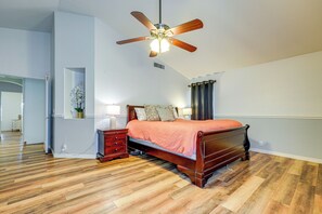 Ein Schlafzimmer mit einem hölzernen Bett, einem Deckenventilator und einem Nachttisch.