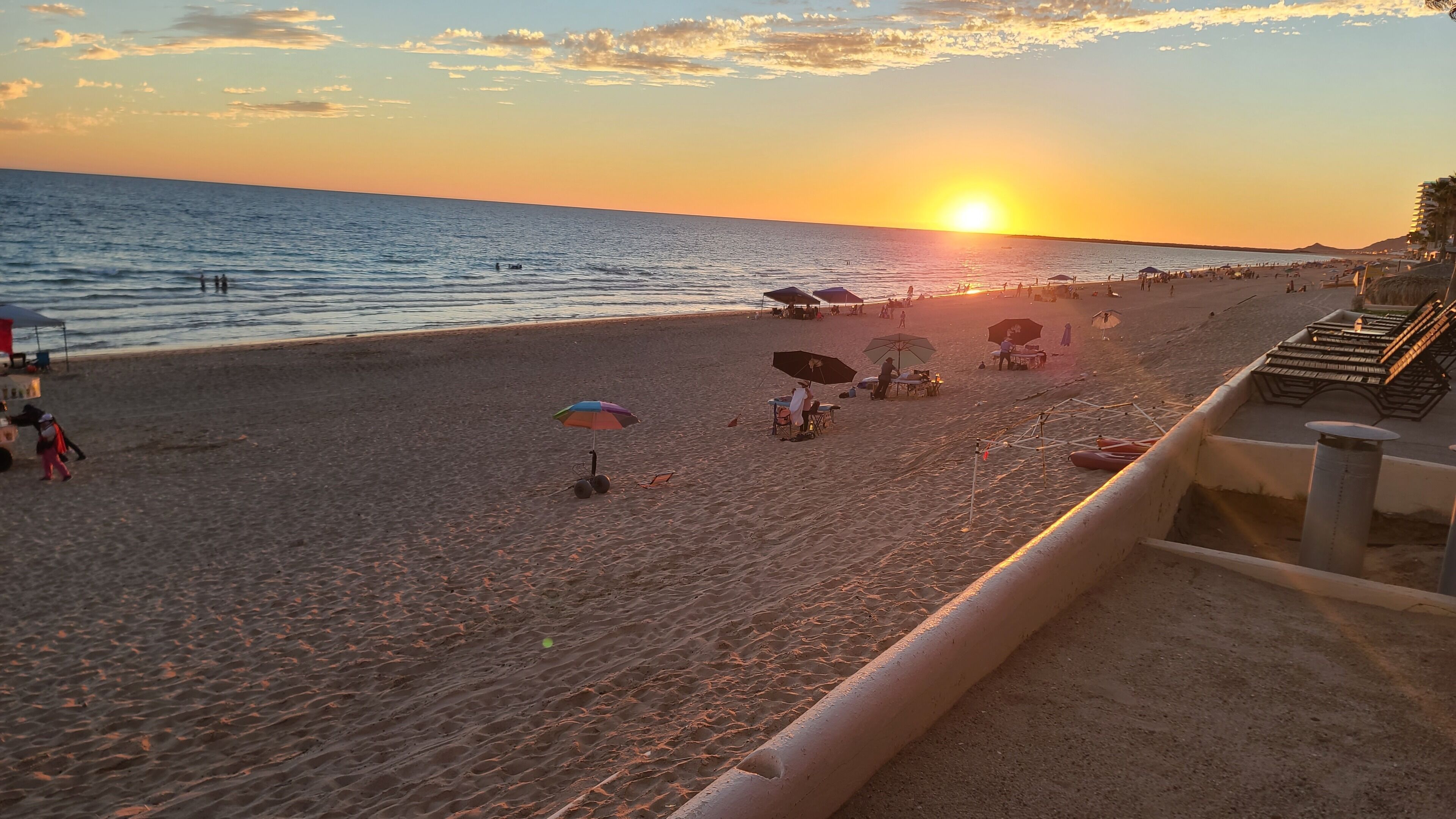 A beach with umbrellas and people.