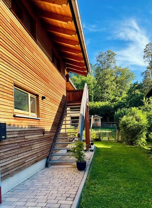 A wooden house with a brick pathway leading to a wooden deck. - 90 m² vacation rental for 2 to 6 people (Staudach-Egerndach)