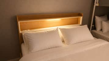 A bed with a wooden headboard and white bedding.
