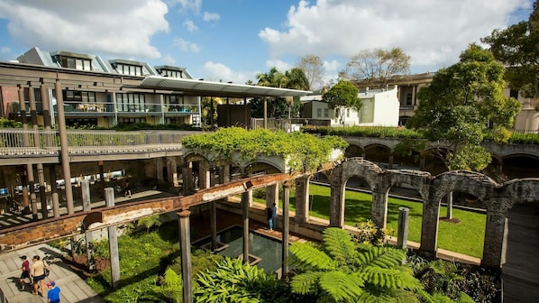 A multi-level courtyard with a bridge, greenery, and classical architecture.
