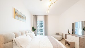 Ein modernes Schlafzimmer mit einem großen Bett, einem Nachttisch, einer Kommode und einem großen Spiegel.
