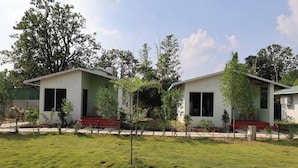 A two-story building with a flat roof, a small porch, and a well-maintained lawn. - Pench Kulamama Safari Resort (Kurai)