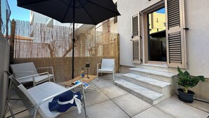 A patio with outdoor seating, a table, and a potted plant. - NG Collection il Barbagia (Alghero)