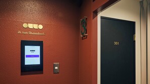 A hotel room with a digital check-in kiosk, a door labeled "301", and a wall-mounted sign with the hotel name. - illi Jam Shinsaibashi (Osaka)
