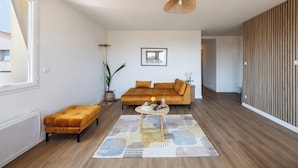 A modern living room with a sofa, ottoman, and a coffee table. - Apartment close to the beach with a view! (Port-de-Bouc)