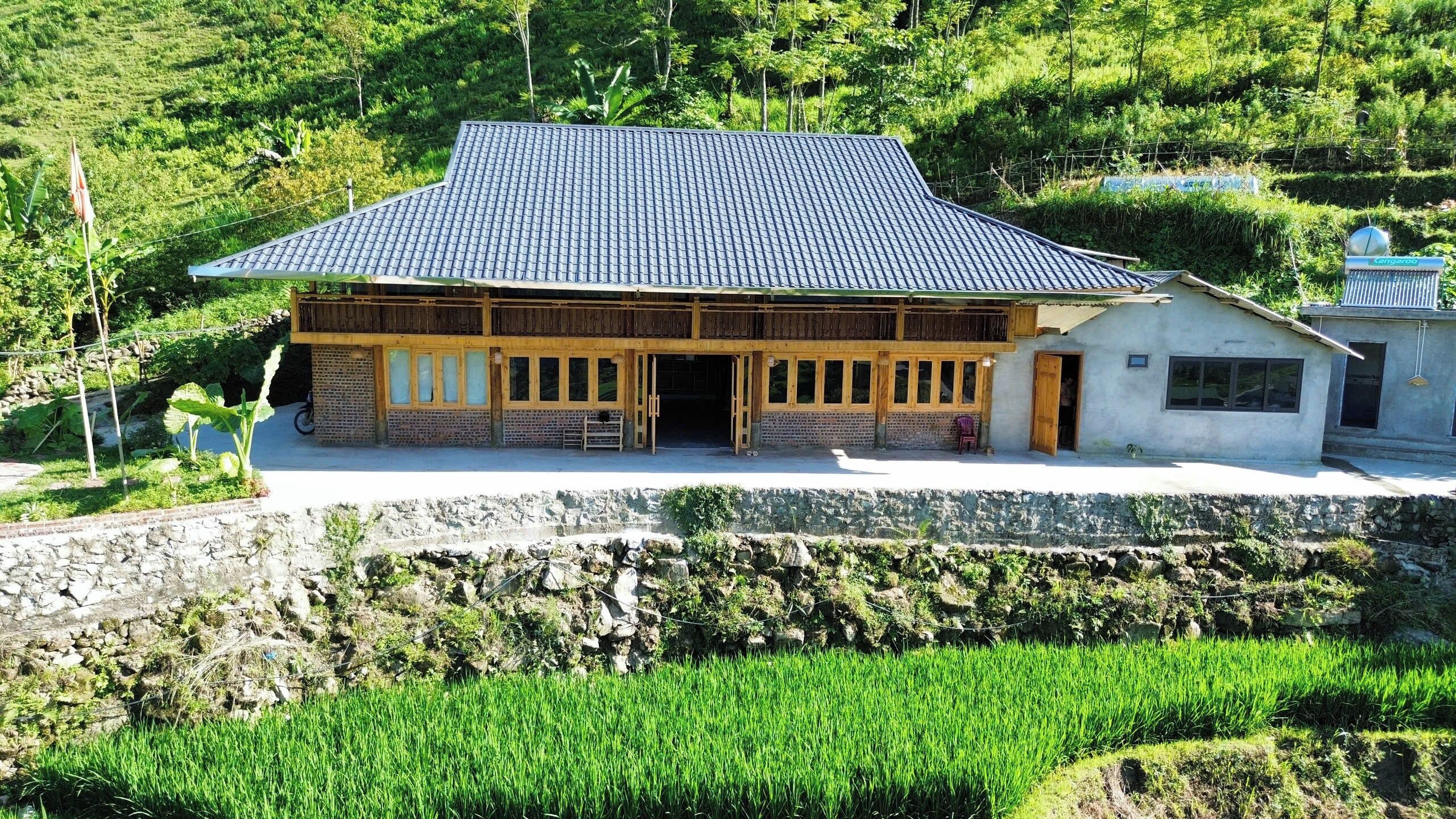 A traditional building with a tiled roof, wooden structure, and a small adjacent structure with a sign.