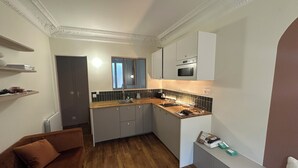 Una cocina compacta con encimera de madera, horno empotrado y ventana sobre el lavamanos.