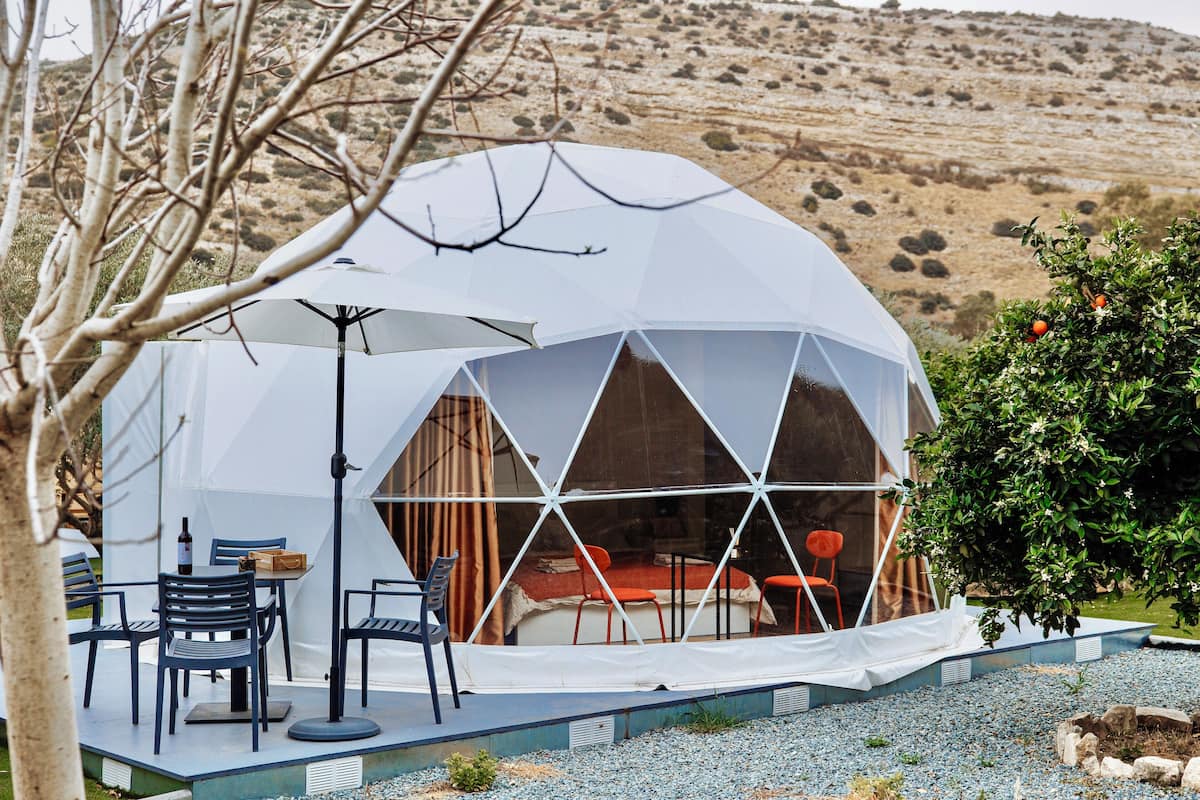 A geodesic dome structure with a dining area, chairs, and a table.