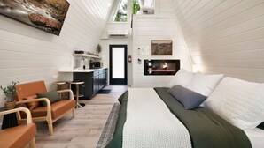 Een gezellig, modern interieur met een slaapkamer in loftstijl, een keuken en een eethoek.