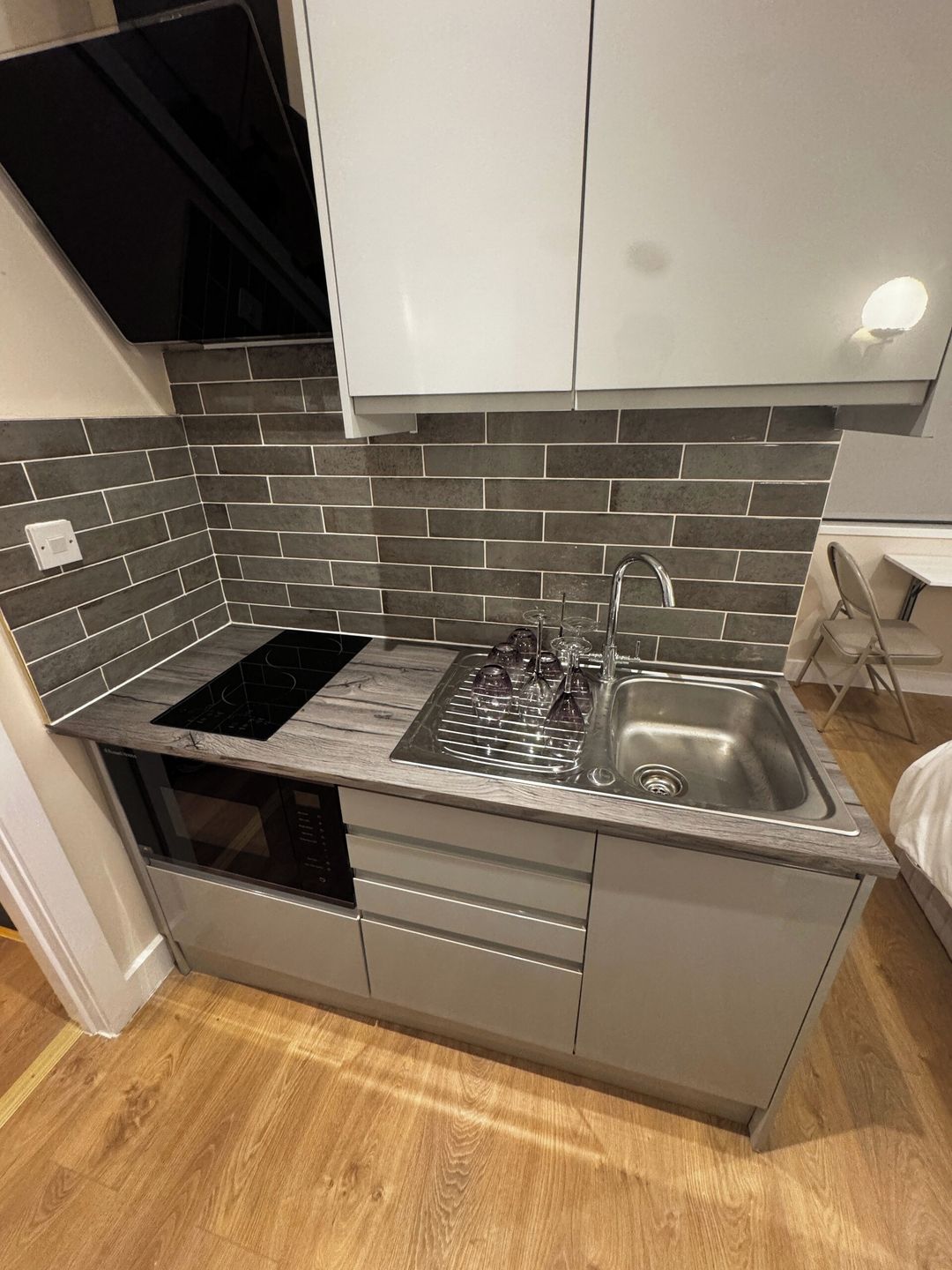 A compact kitchen with a built-in stove, a sink, and a dishwasher.