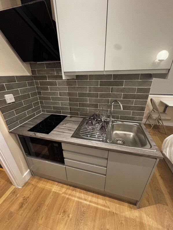 A compact kitchen with a built-in stove, a sink, and a dishwasher.