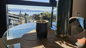 A table with a glass top, a metal water bottle, and a small black container with a plant. - Paradise view Bariloche (San Carlos de Bariloche)