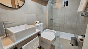 A modern bathroom with a large bathtub, a toilet, and a glass-enclosed shower area. - Paradise view Bariloche (San Carlos de Bariloche)