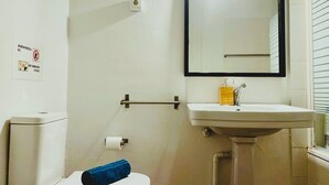 A small bathroom with a toilet, a sink, and a mirror. - Beautiful apartment in the center of Barcelona (Barcelona)