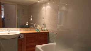 Un baño con lavabo, tocador y bañera.
