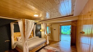 Une chambre à coucher avec un lit à baldaquin, un plafond en bois et une vue sur l’extérieur.