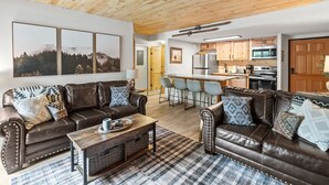 A spacious living area with two leather sofas, a coffee table, and a kitchen in the background. - Ski-In/Out Luxury•1 Blk to Main•Pool+Hot Tub•Sauna (Breckenridge)