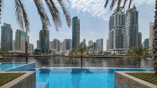 Una piscina con el horizonte de una ciudad al fondo.