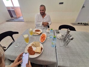 Une table à manger avec de la nourriture, des boissons et des couverts.