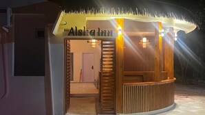 A small, well-lit building with a thatched roof and the name "Alsha Inn" visible. - Alsha Inn Dhiffushi (Dhiffushi)