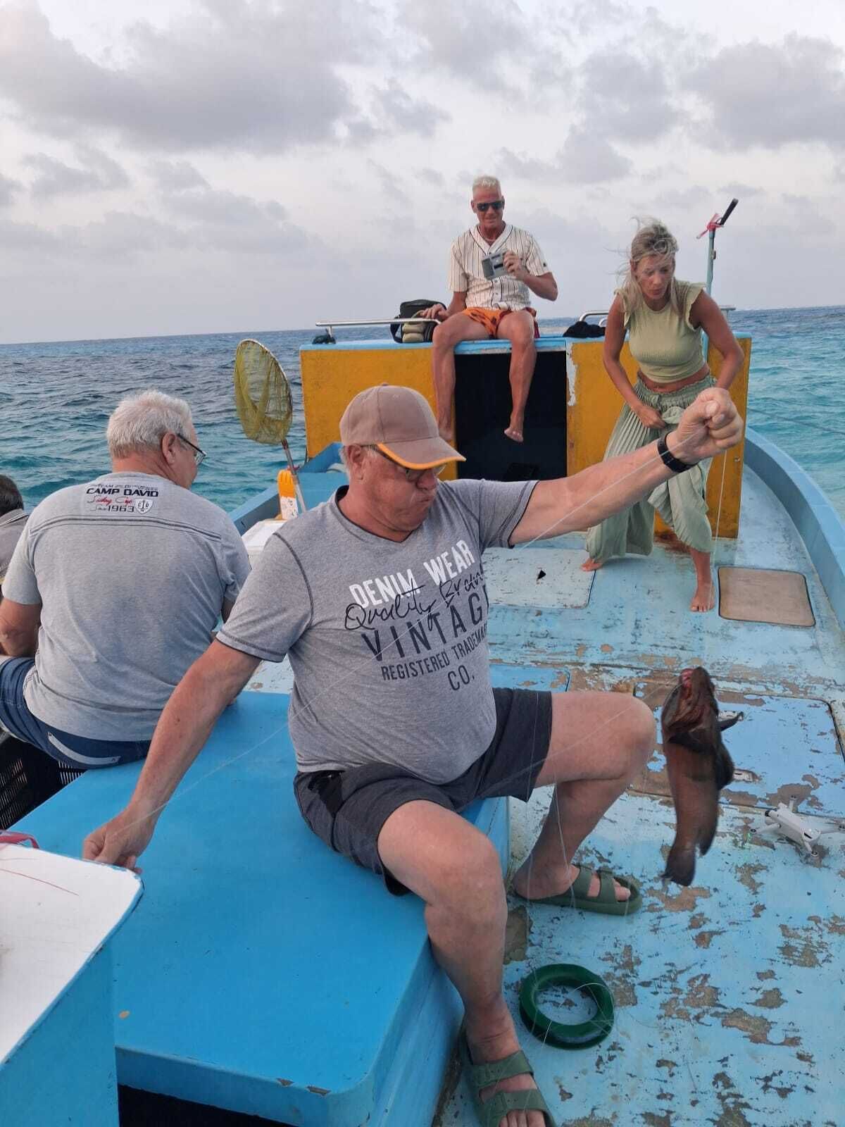 A boat with people on deck, a blue interior, and a person holding a camera.