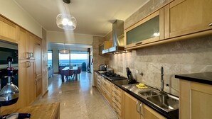A modern kitchen with wooden cabinets, a stainless steel sink, and a view to the outside. - Luz by Check-in Portugal (Lagos)