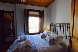 A bedroom with a bed, a window, and a door. - Idyllic Andalusian villa with private pool & stunning views (Riogordo)