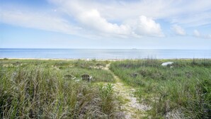 A beach path leading to the ocean with a chair and a sign, surrounded by grass and dunes. - On Beach 5BD+7BA: Sauna|HotTub|Billards|FencedDeck (Norfolk)